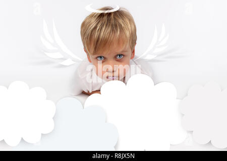 Naughty or good child for Christmas card? PF or letter to Santa-Claus for Christmas. Little child boy appearing as an adorable angelic devil Stock Photo