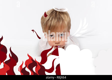 Naughty or good child for Christmas card? PF or letter to Santa-Claus for Christmas. Little child boy appearing as an adorable angelic devil Stock Photo