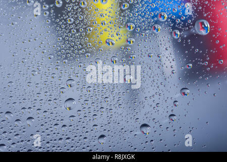 Water drops, rain drops or droplets on glass with push pins in the background on rainy days. Stock Photo