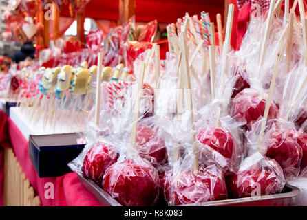 Red glazed candy apples wrapped in cellophane on display in Christmas street fair market Stock Photo