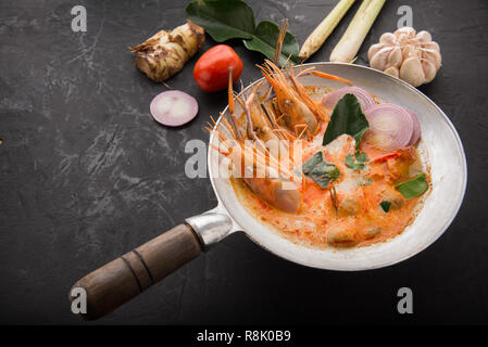 Tom Yum Goong Spicy Sour Soup on wooden table top view, famous Thai food cuisine calling Tom Yum Kung Stock Photo