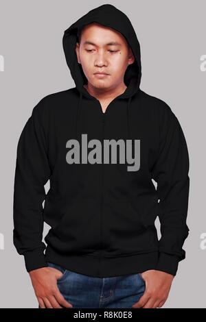 Blank sweatshirt mock up, front view, isolated on grey. Asian male model wear plain black hoodie mockup. Hoody design presentation. Jumper for print.  Stock Photo