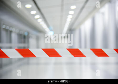 Red and White Lines of barrier tape. At subway station of airport background.Red White warning tape pole fencing is protects for No entry Stock Photo