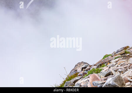 harsh mountain stones colored in soft pastel colors with fog behind Stock Photo