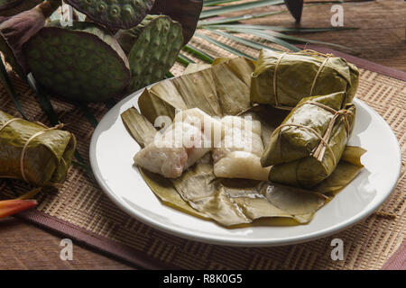 khao tom mad Thai food style dessert, made from banana and glutinous rice, wrap with banana leaf on wooden table Stock Photo