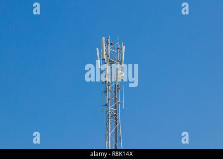 Silver color mobile,cell phone tower with trees and blue sky Stock Photo