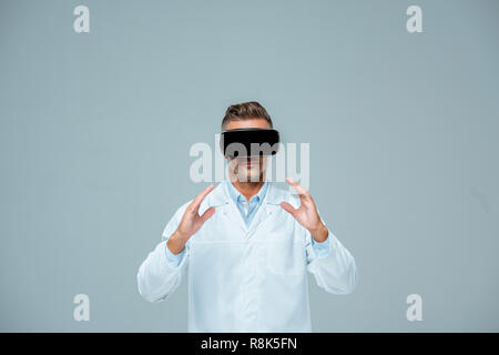 scientist in virtual reality headset holding something isolated on grey, artificial intelligence concept Stock Photo