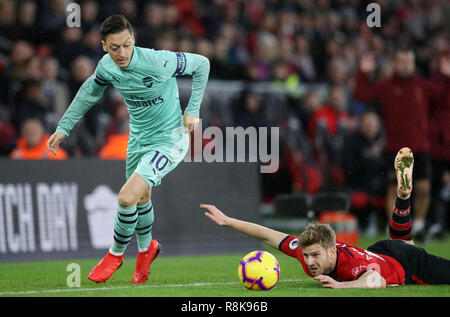 Arsenal's Mesut Ozil jumps over a challenge from Southampton's Stuart Armstrong during the Premier League match at St Mary's Stadium, Southampton. Stock Photo