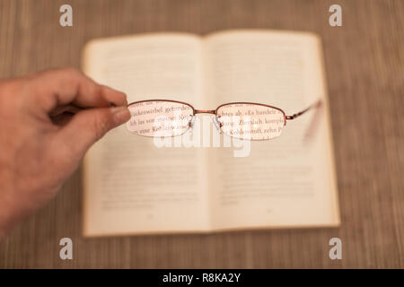 hand holding eyeglasses makes the letters high visibility and a clear sharp optic