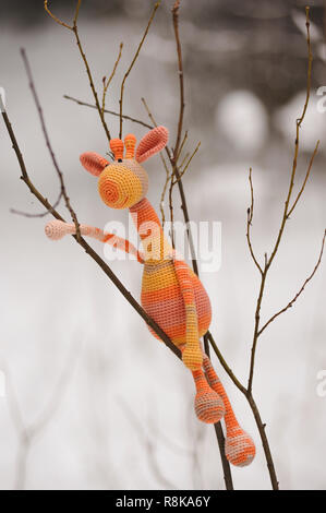 SYKTYVKAR, RUSSIA - DECEMBER 16, 2018: Illustrative image. Resting giraffe toy knitted in the technique of knitting amigurumi Stock Photo