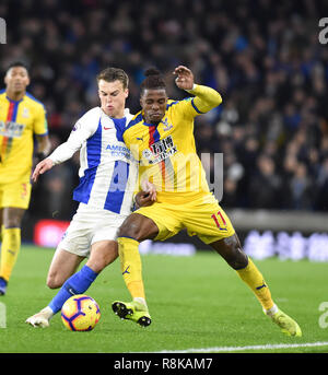 Solly March of Brighton tackles Wilfred Zaha of Crystal Palace during the Premier League match between Brighton & Hove Albion and Crystal Palace at the Amex Stadium . 04 December 2018 Editorial use only. No merchandising. For Football images FA and Premier League restrictions apply inc. no internet/mobile usage without FAPL license - for details contact Football Dataco