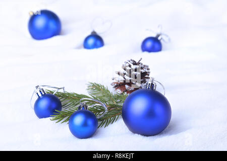 Christmas or holiday composition with blue balls on billowy feathers with snow and snowflakes. Stock Photo