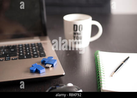 still life with blocknote, labtop, pen and a white mug of coffee over a black office desk. symbol of job Stock Photo