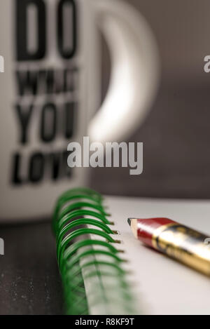 still life with blocknote, labtop, pen and a white mug of coffee over a black office desk. symbol of job Stock Photo