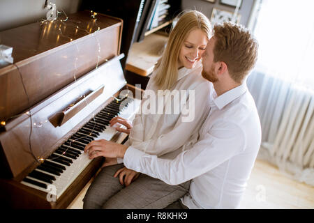 Naked woman in apartment playing piano Stock Photo - Alamy