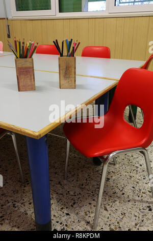 red chair in the class room of a school and many pencil on the table Stock Photo