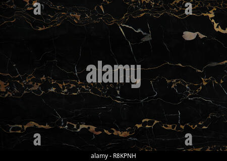 Black marble with yellow veins Nero Portoro as background. Stock Photo