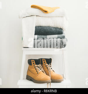 Pile of warm sweaters, blankets, cap and boots, square crop Stock Photo