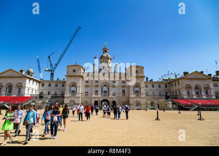 Tourists walk towards the arch of Horse Guards Parade under a winter's blue sky, Whitehall, London, England, United Kingdom Stock Photo