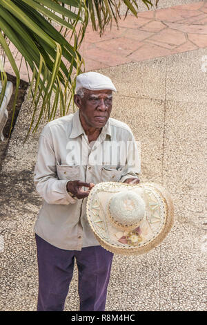 elderly man in cap sells straw hats in Havana Cuba Stock Photo