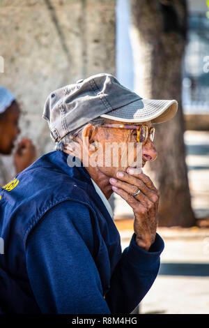very old wrinkly man strokes chin in Havana Cuba Stock Photo