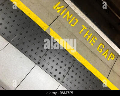 Tilted photo of Mind the gap sign. Typical London underground Mind the gap between the train and the platform. Stock Photo