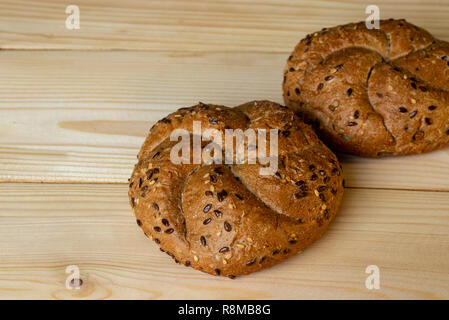 Buns of coarse flour with seeds and grains on a wooden background close-up. Stock Photo