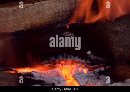 bright burning firewood close up view, red glowing pieces of firewood in a indoor fireplace abstract macro shot Stock Photo