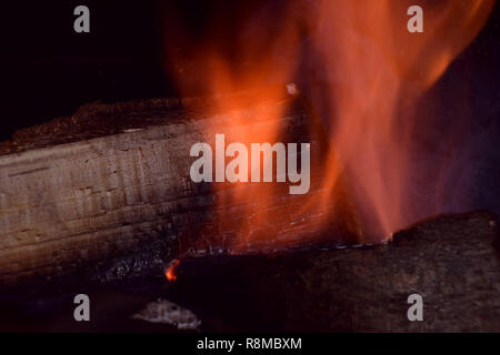 A closeup shot of pieces of wood burning inside old metal oven