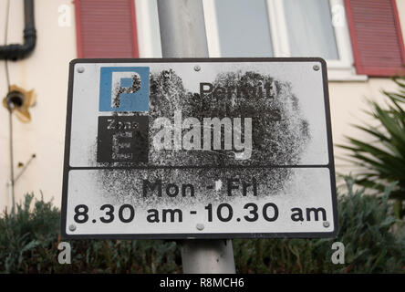 partially blacked out british road sign giving detalls of street parking restrictions, in twickenham, middlesex, england Stock Photo