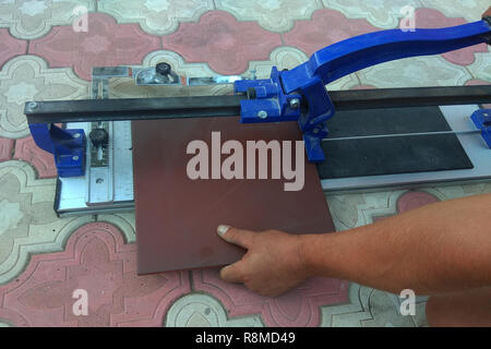 the worker cuts the ceramic tile on the manual tile 2018 Stock Photo