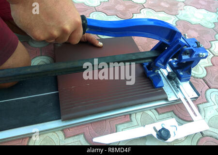 the worker cuts the ceramic tile on the manual tile 2018 Stock Photo