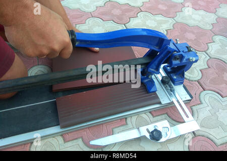 the worker cuts the ceramic tile on the manual tile 2018 Stock Photo