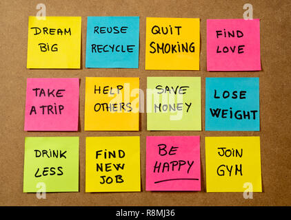 New Year's resolution written on cork board with colorful memo notes of dreams wishes and trendy lettering post its for happy life style Goals and sel Stock Photo