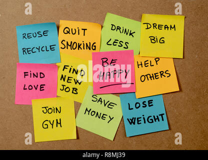 New Year's resolution written on cork board with colorful memo notes of dreams wishes and trendy lettering post its for happy life style Goals and sel Stock Photo