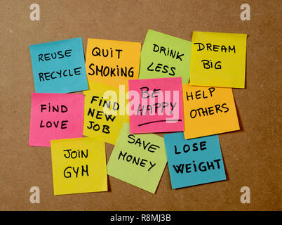 New Year's resolution written on cork board with colorful memo notes of dreams wishes and trendy lettering post its for happy life style Goals and sel Stock Photo