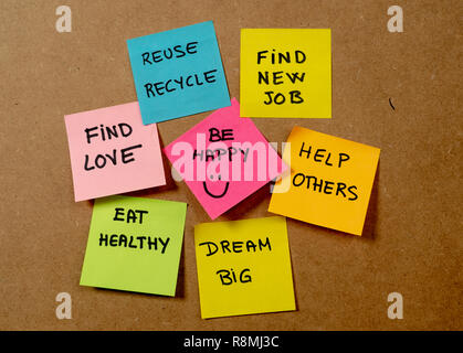 New Year's resolution written on cork board with colorful memo notes of dreams wishes and trendy lettering post its for happy life style Goals and sel Stock Photo