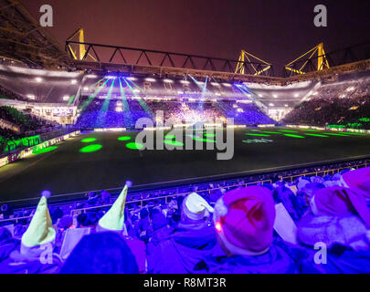 Dortmund, Germany. 16th Dec, 2018. People with yellow and red pointed caps sat in the Signal Iduna Park in the stands of Germany's biggest Christmas song, according to the organisers. 50,000 singers were expected in the BVB stadium. Credit: Bernd Thissen/dpa/Alamy Live News