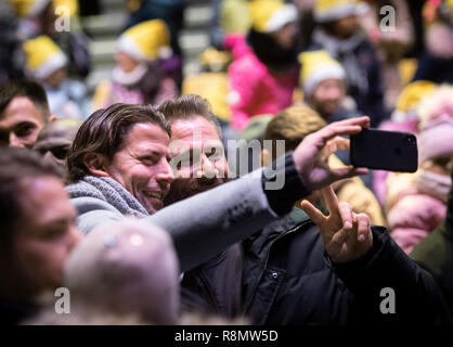 Dortmund, Germany. 16th Dec, 2018. Former goalkeeper Roman Weidenfeller (l) and singer Sascha photograph each other with a smartphone during Germany's biggest Christmas song in Signal Iduna Park, according to the organizers. 50,000 singers were expected in the BVB stadium. Credit: Bernd Thissen/dpa/Alamy Live News