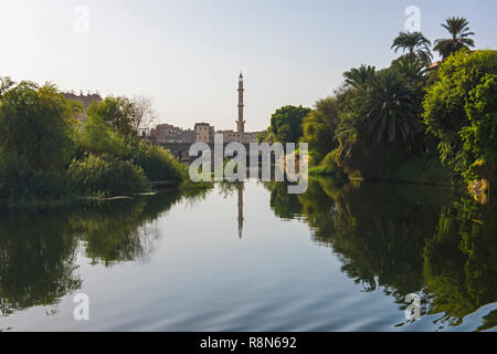 View across large wide river Nile in Egypt at Edfu through rural countryside landscape with mosque and town Stock Photo