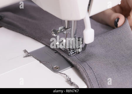 Close-up of hands sewing on machine Selected focus Stock Photo