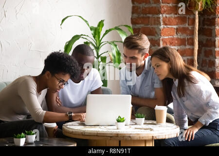 Focused African American woman with friends using laptop Stock Photo