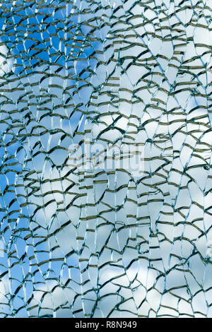 Cloudy sky view through broken glass. Broken glass texture. Abstract background. Stock Photo