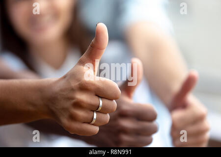 Happy multiethnic friends showing thumbs up close up Stock Photo