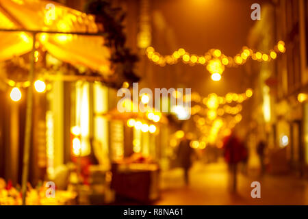 Golden Christmas lighting decoration in the city center​ of Dordrecht  shopping street full with bokeh lighting and blurred people walking Stock Photo