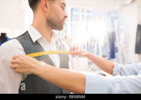 Man Getting Fitted for Bespoke Suit in Atelier Stock Photo