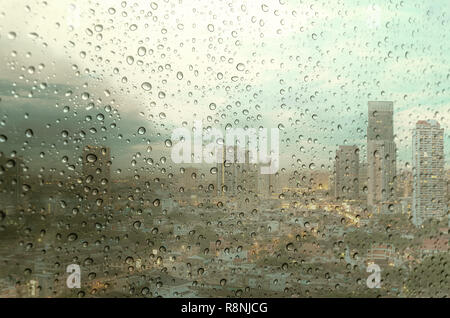Waterdrops on a glass surface windows with cityscape background Stock Photo