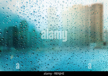 Waterdrops on a glass surface windows with cityscape background Stock Photo