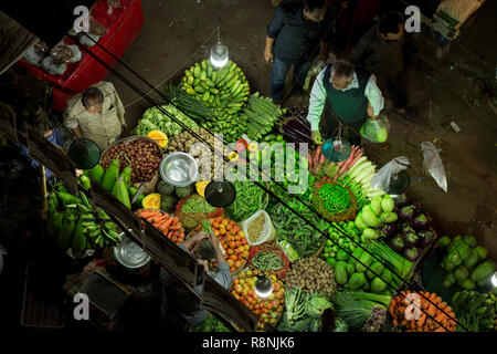 DHAKA, BANGLADESH - DECEMBER 15 : Bangladeshi people browsw vegetable  in a street vegetable market at night in Dhaka, Bangladesh on December 15, 2018 Stock Photo