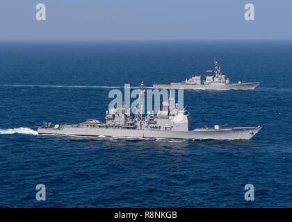 The U.S. Navy guided-missile cruiser USS Mobile Bay, front, and the guided missile destroyer USS Decatur sail in formation during patrol December 14, 2018 in the Arabian Sea. Stock Photo